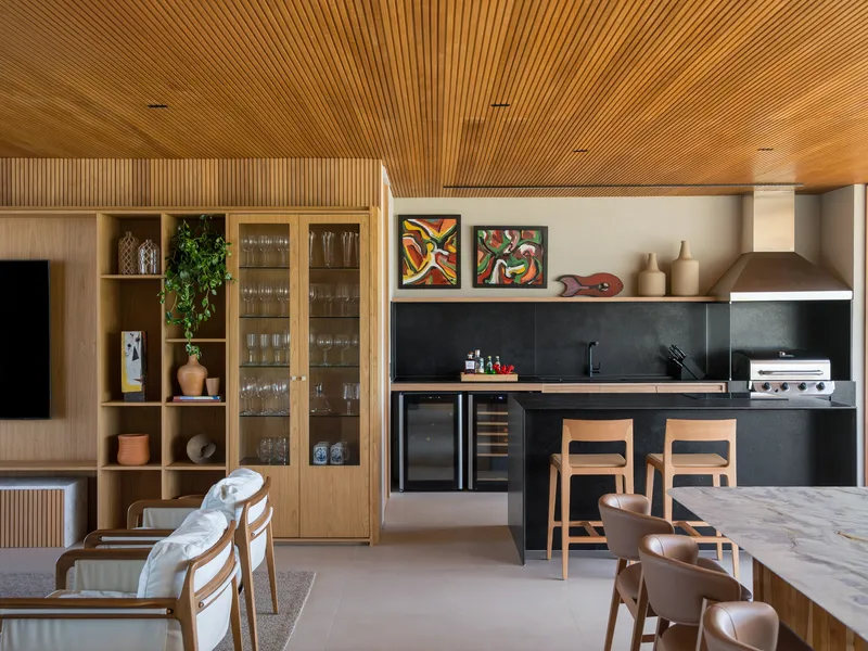 Open kitchen area with black stone counters and backsplash beneath a continuous slatted timber ceiling