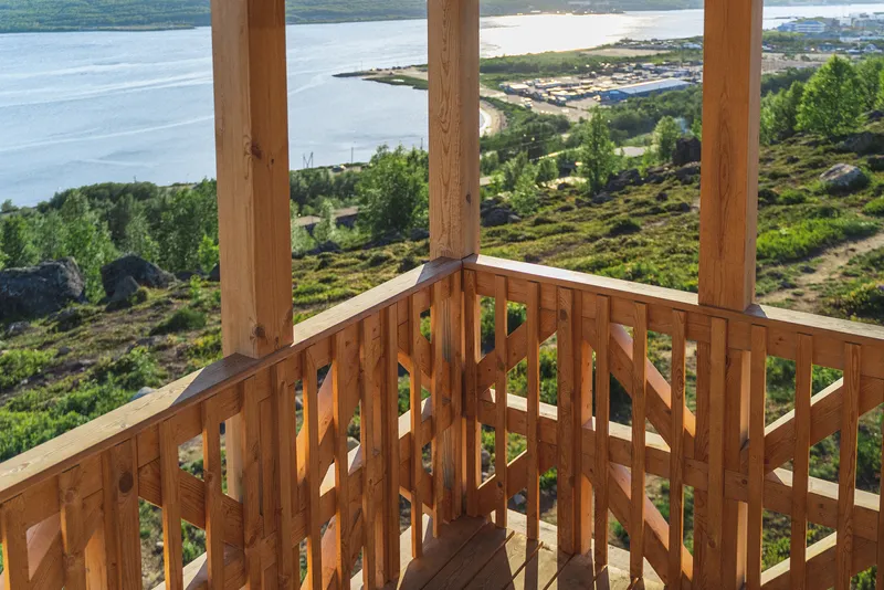 Corner detail of the open timber railing with triangular cutouts framing the valley below