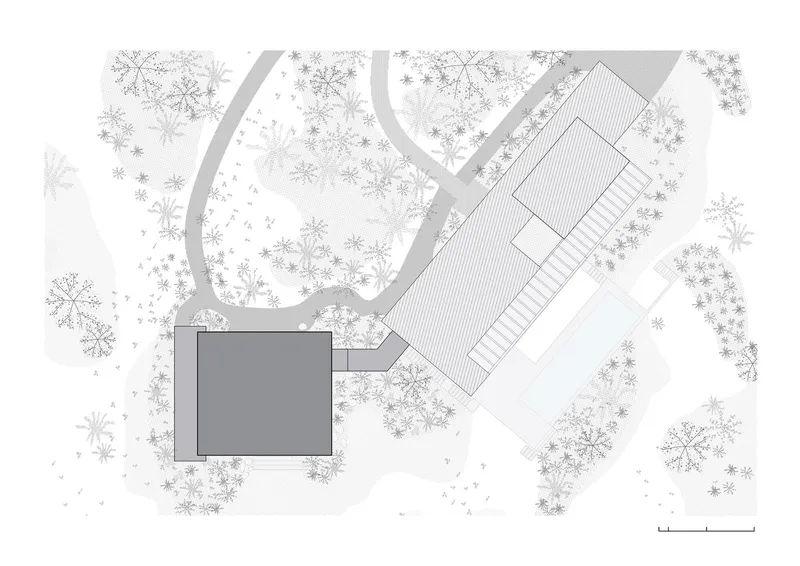 Site plan drawing showing two volumes connected by a covered walkway among dense tree canopy