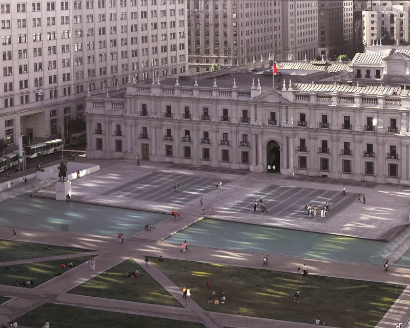 Aerial view of the paved plaza with triangular water features and people gathered below