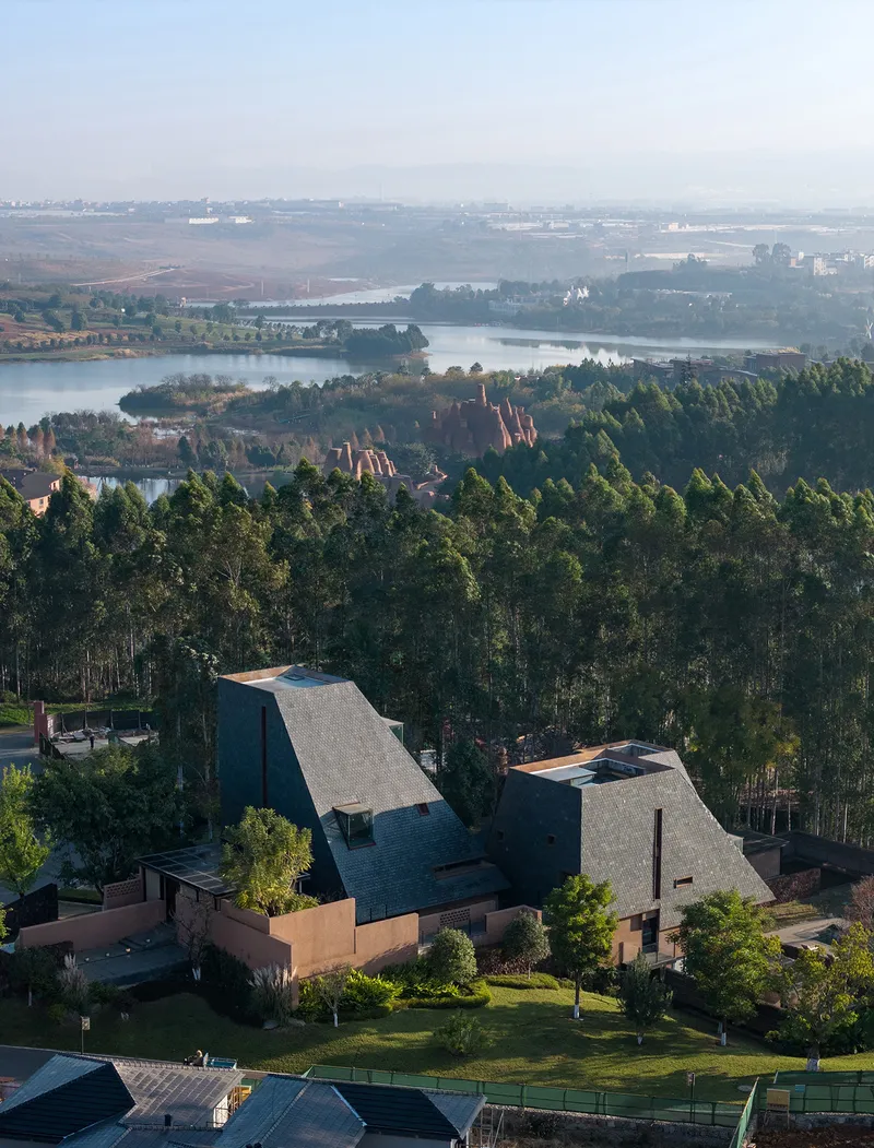 Aerial view of the tiled pyramidal roofs surrounded by dense eucalyptus forest and distant lakes