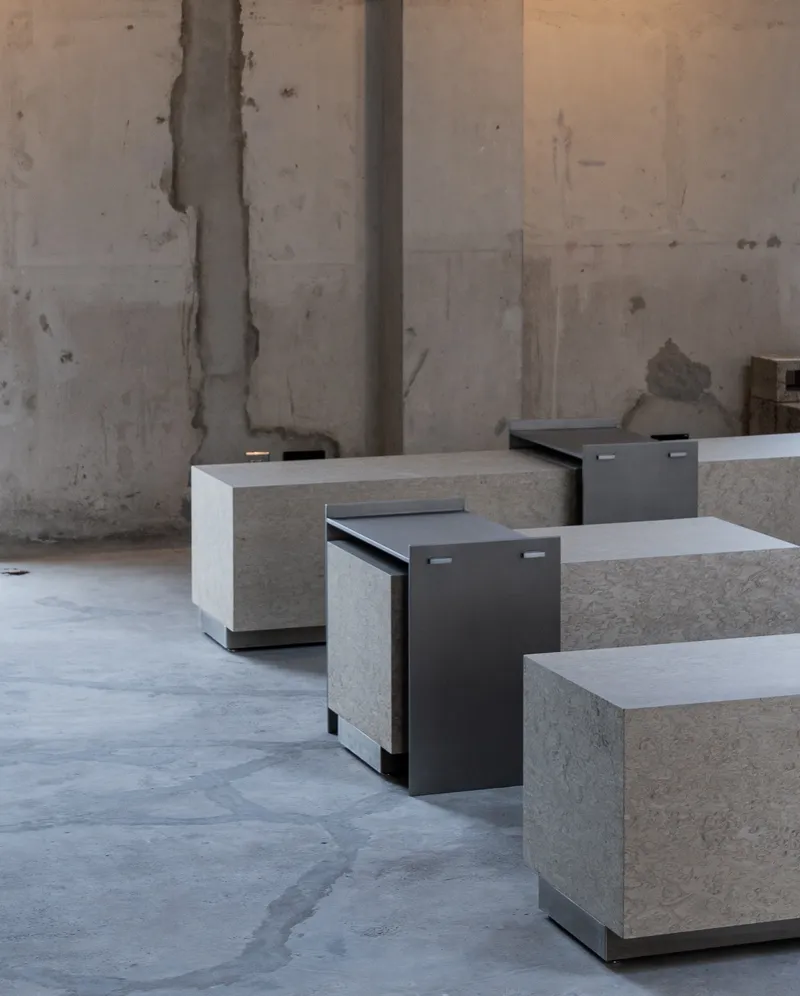 Concrete block seating units with blackened steel pull-out seats on a polished floor