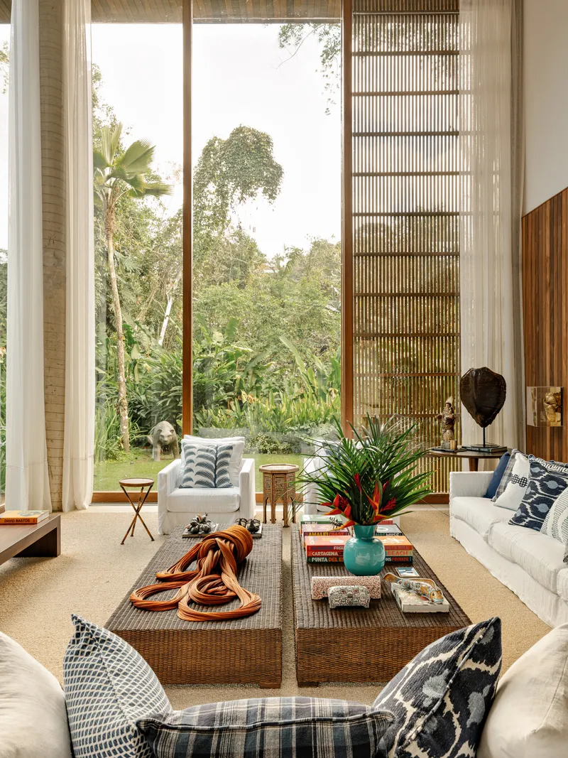 Double-height living room with full-height windows, timber brise-soleil screen and garden view