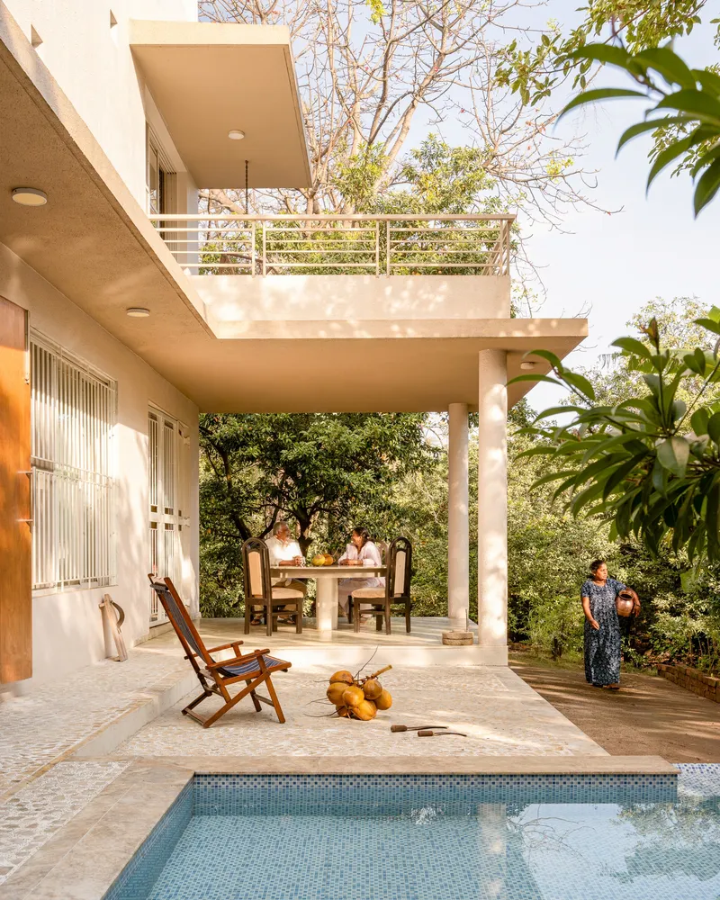 Rear courtyard with swimming pool, cantilevered terrace, and horizontal railing under dappled tree shade