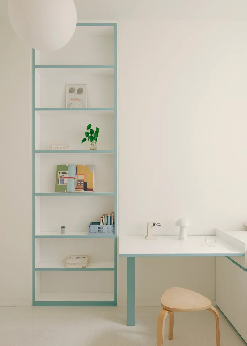 Pale blue steel shelving and desk unit with bentwood stool in soft natural light