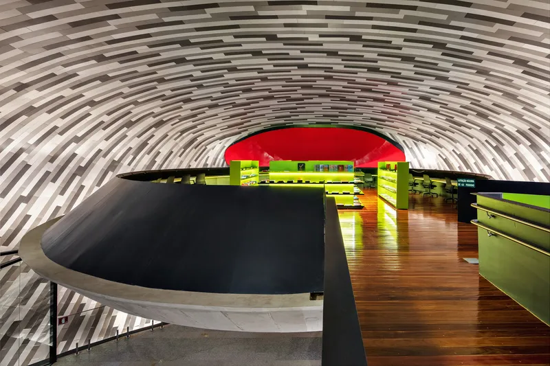 Curved service counter with black top and chartreuse base under a striped grey vaulted ceiling