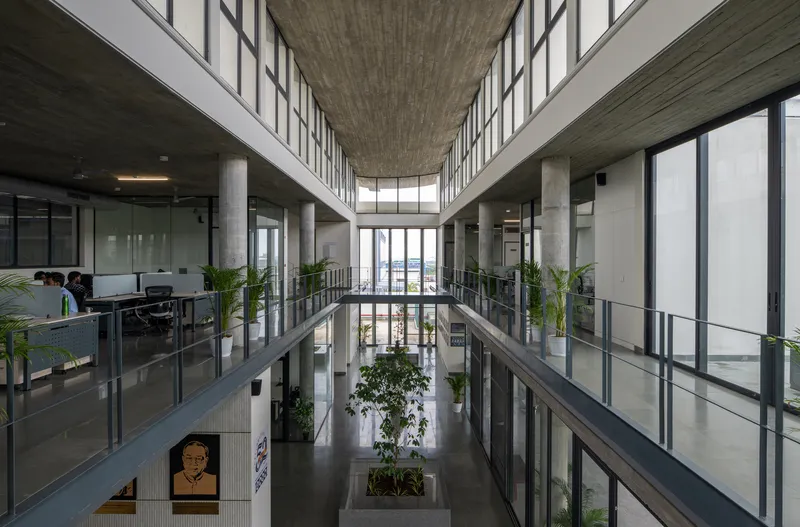 Central atrium corridor with glazed office frontages on three levels and planted interior beds below
