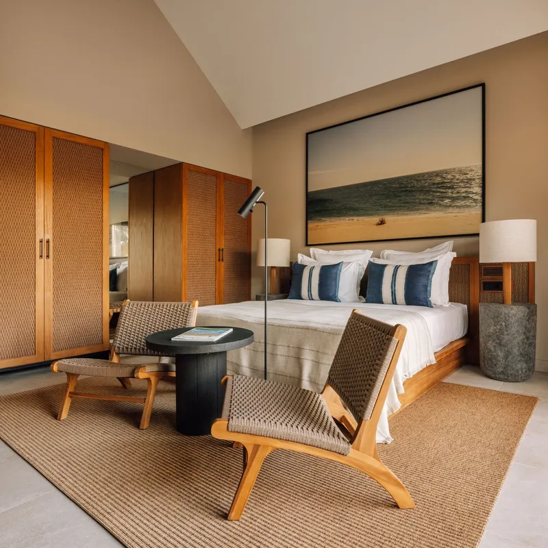 Bedroom with woven-panel timber wardrobes and vaulted ceiling above the platform bed