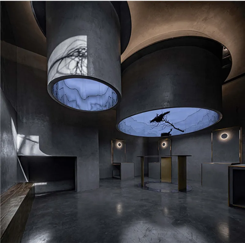 Dark art space with cylindrical gallery volumes and atmospheric lighting.