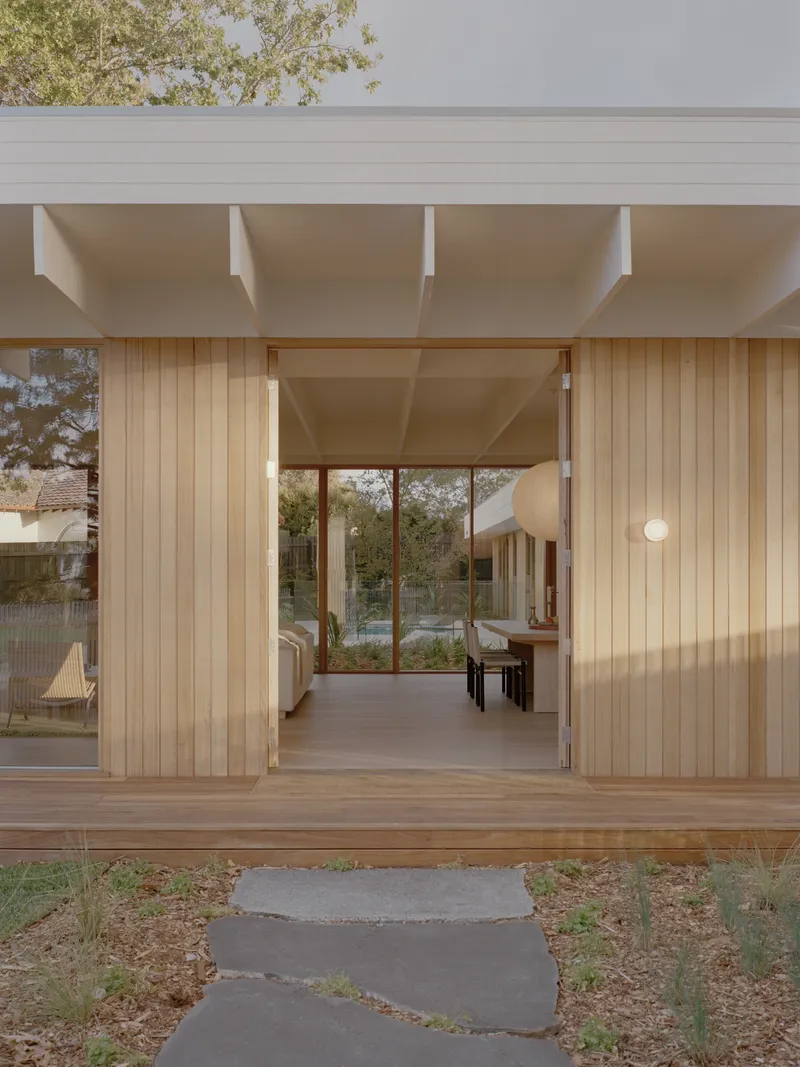Entry threshold with sliding timber doors and stone pavers leading through covered porch