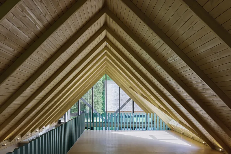 Interior view of exposed timber rafter ceiling forming a symmetrical triangular vault