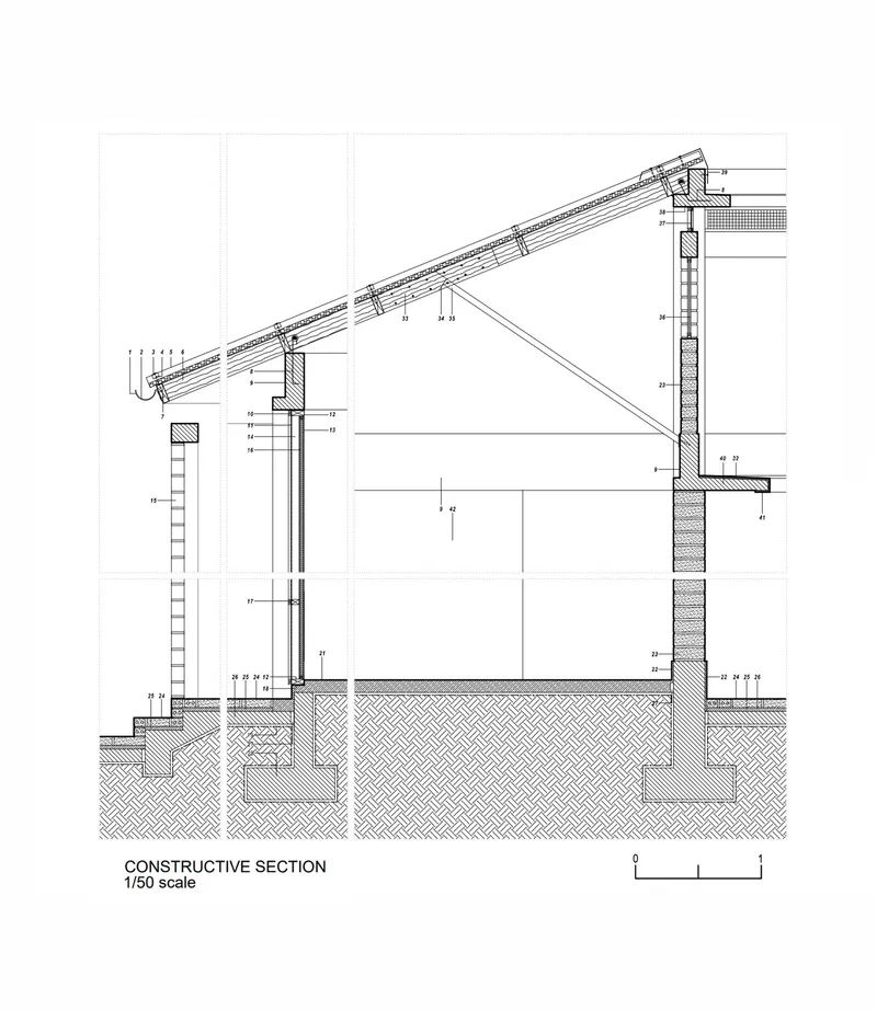 Constructive section drawing detailing the foundation, wall assembly, and angled roof framing system