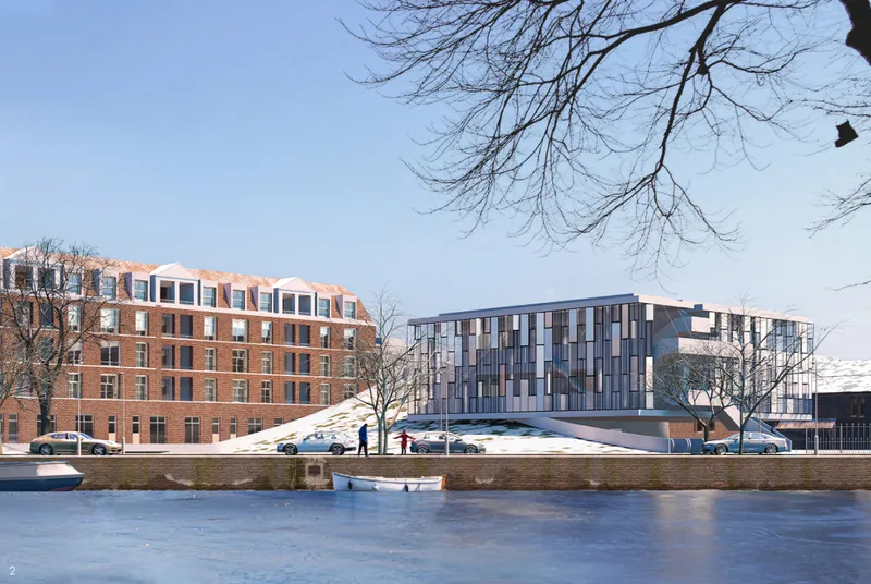 Canal-side view reveals the cultural center’s contemporary glass volume and landscaped form