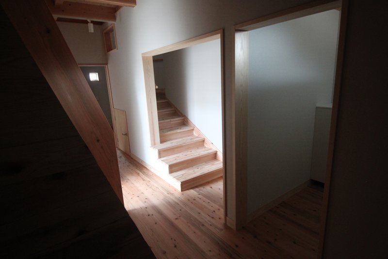 Timber staircase framed by white walls and timber doorways under diffused natural light