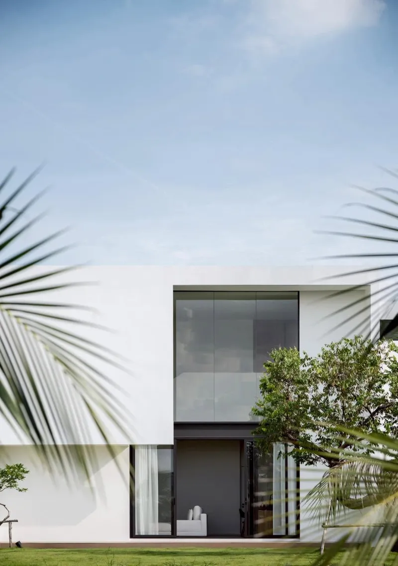 Garden facade with stacked glazing and dark metal frames framed by palm fronds