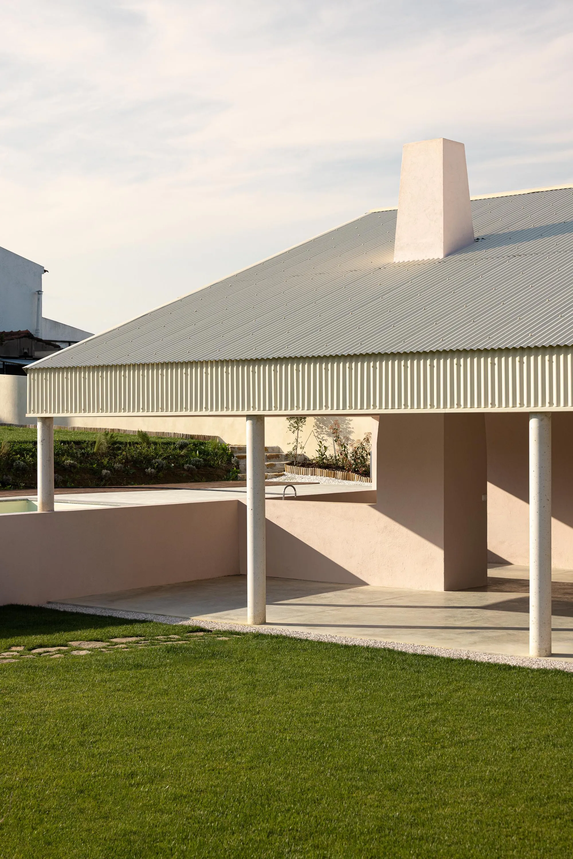 Vasco Burnay Wraps a Pink L-Shaped House in a Deep South-Facing Porch in Vila Franca de Xira