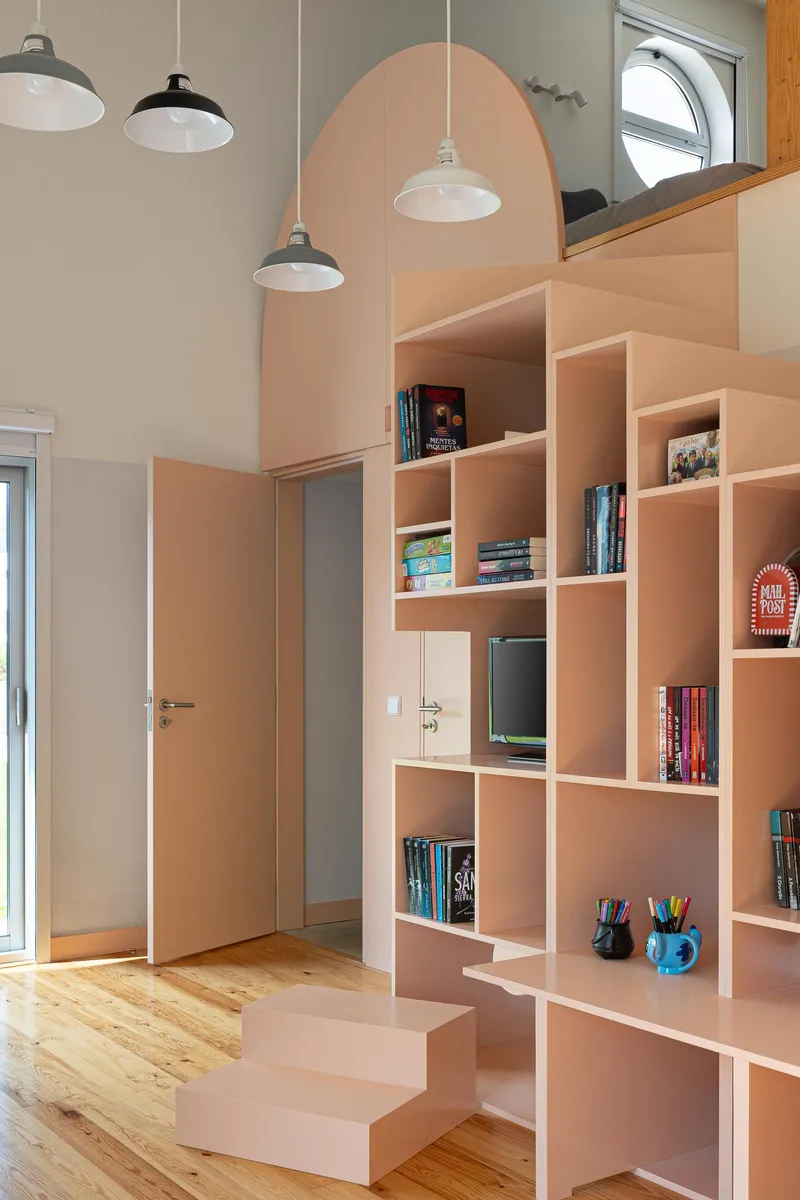 Pink plywood shelving unit with arched opening and stepped base under pendant lamps