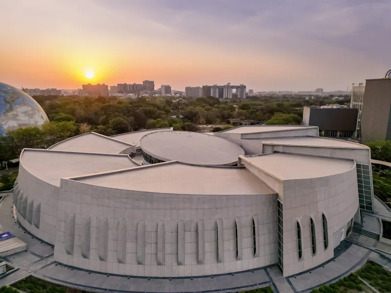 Aerial view of the cloverleaf-shaped roof with vertical window slits at sunset