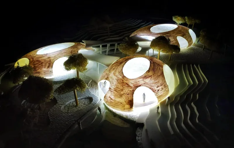 Illuminated architectural model showing the river-inspired aquarium form merging with landscape and water.