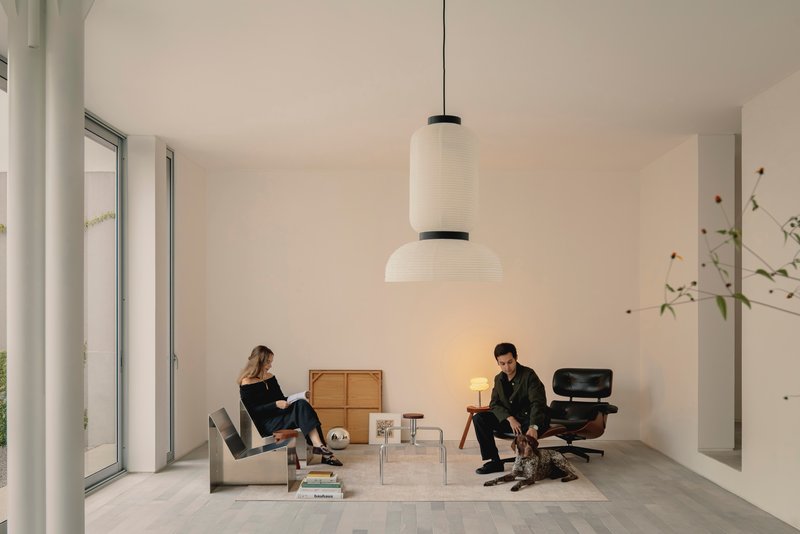 Living room with two seated figures beneath a layered pendant light fixture