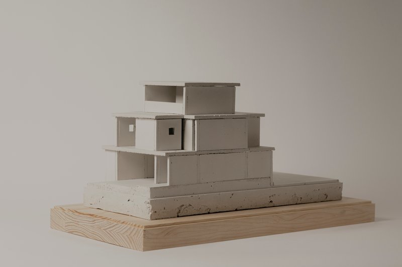 Front elevation of the model revealing stacked volumes with cantilevered slabs and recessed openings