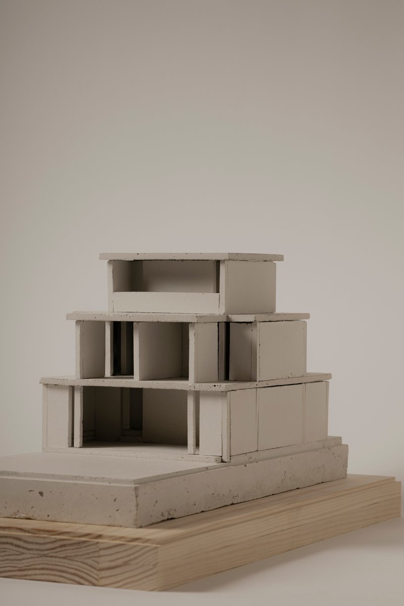 Sectional view of a concrete massing model revealing internal columns and terraced levels