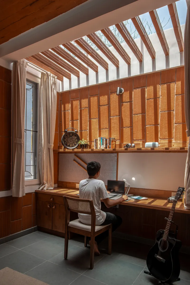 Study nook with timber ceiling slats and a person seated at the built-in desk