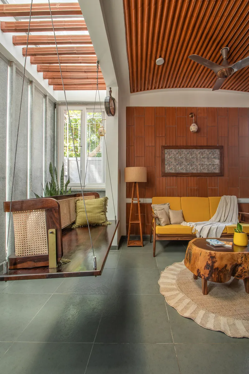 Open living space showing suspended cane swing and timber slatted ceiling with clerestory light
