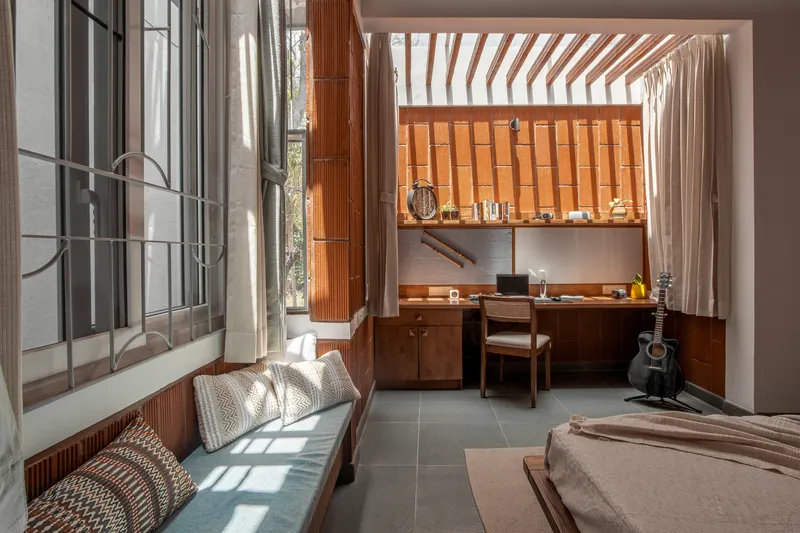 Bedroom with view through to the study area and timber wall panels in morning light