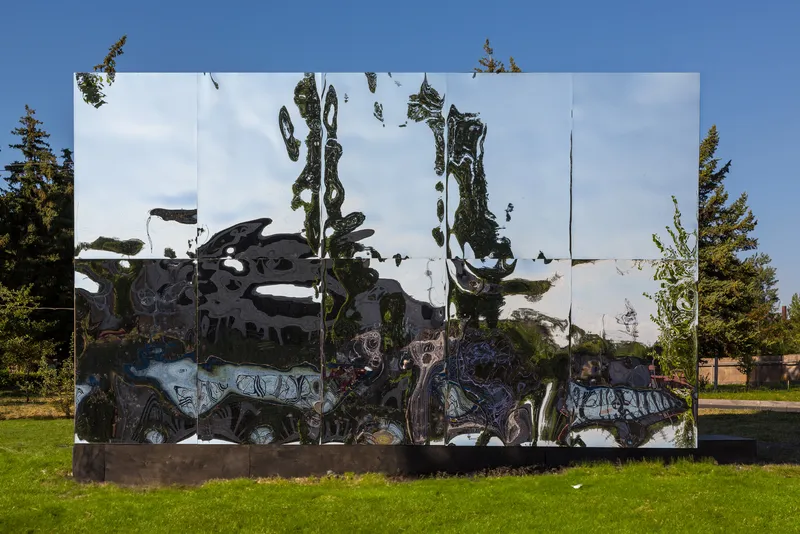 Mirrored surface distorting views of surrounding trees and lawn under bright afternoon sun