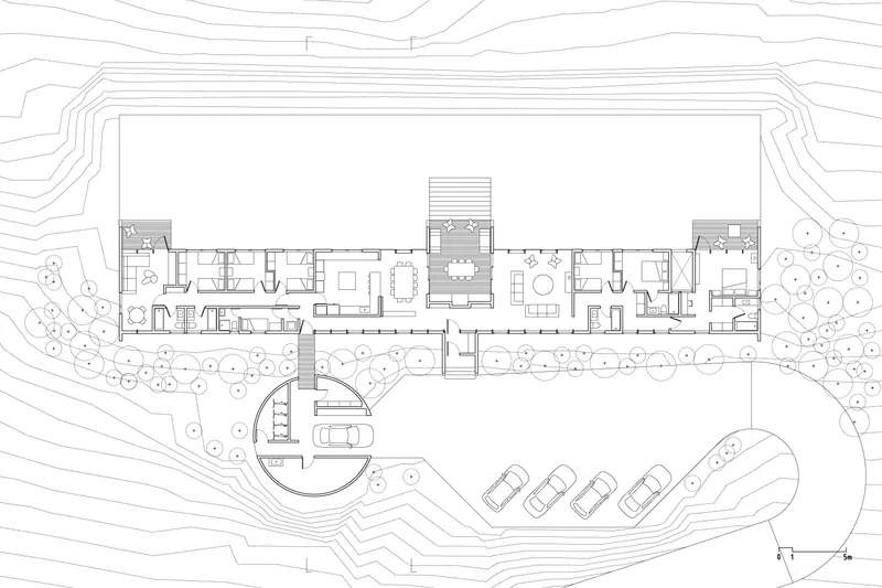 Site plan drawing showing the linear building footprint with curved parking area and surrounding topography