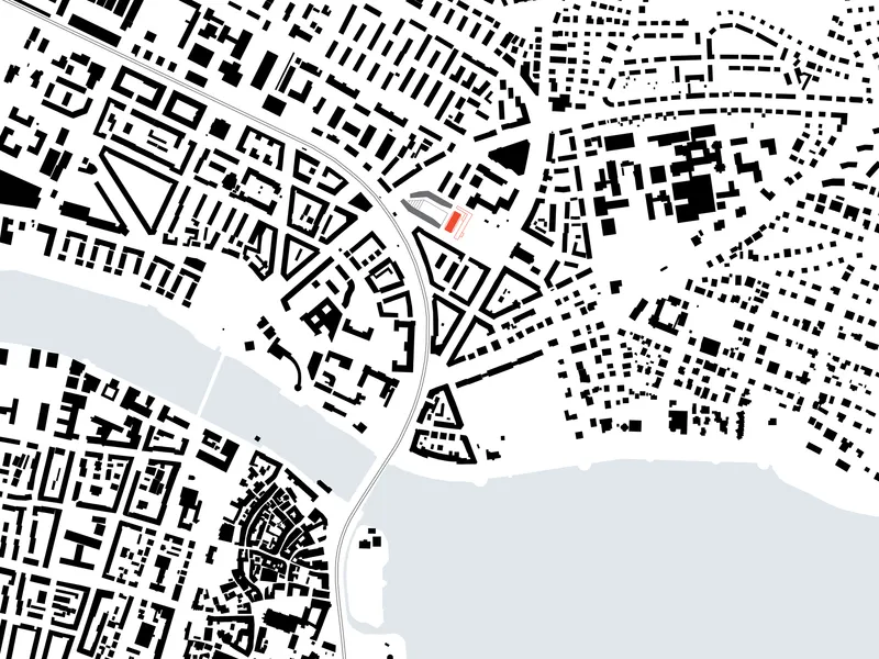 Site plan drawing showing the building footprint adjacent to a waterfront and dense urban fabric
