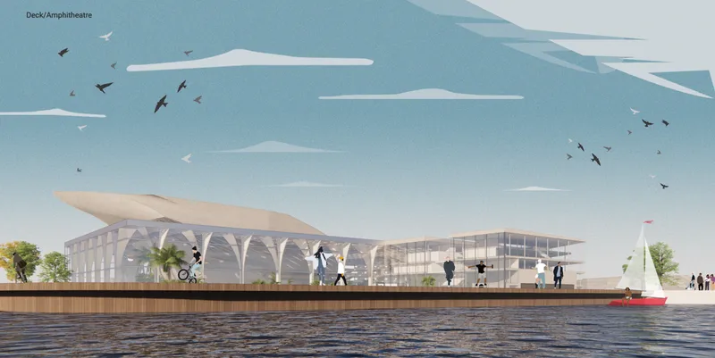 View from the waterside showing the transparent facade and flowing roof canopy with sailboats passing
