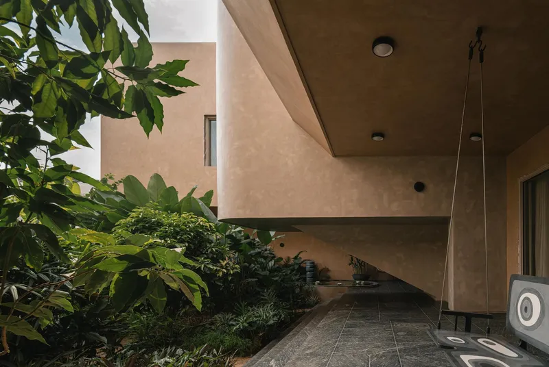 Covered walkway with cantilevered soffit and planted garden bed framed by concrete walls