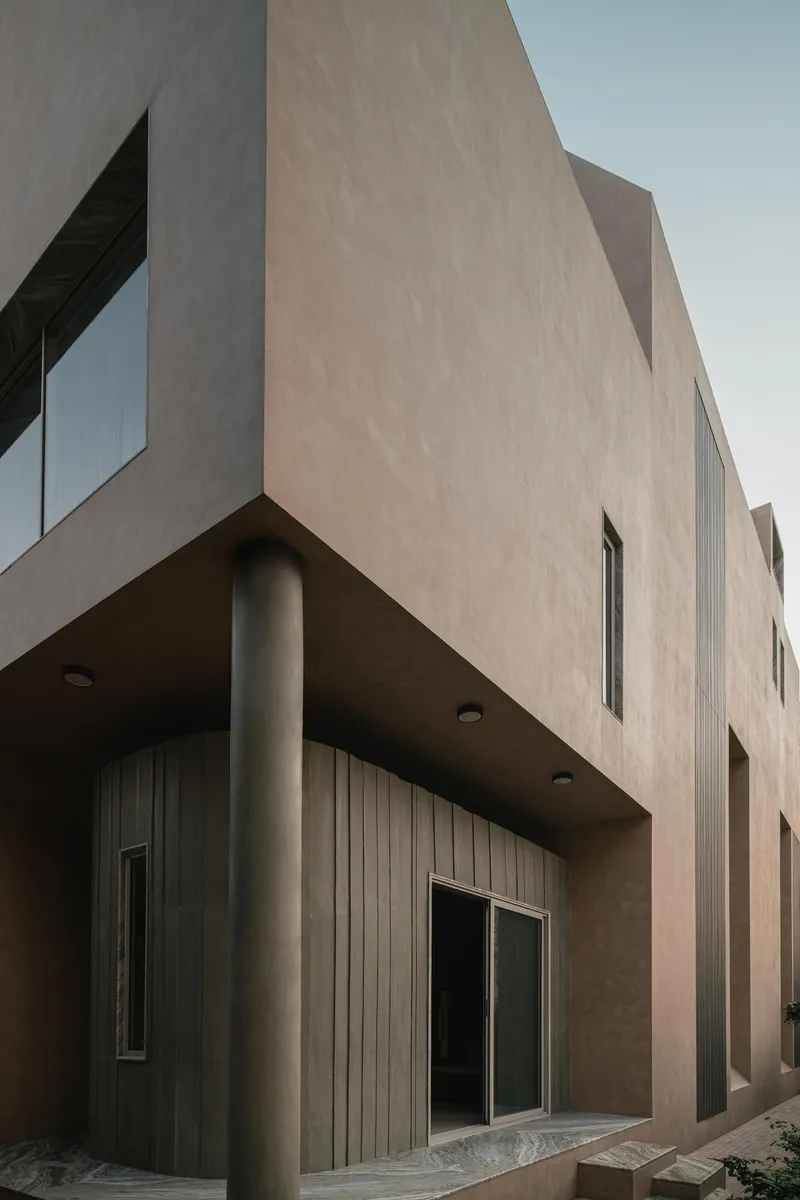 Exterior corner showing cantilevered volumes supported by cylindrical columns and timber cladding