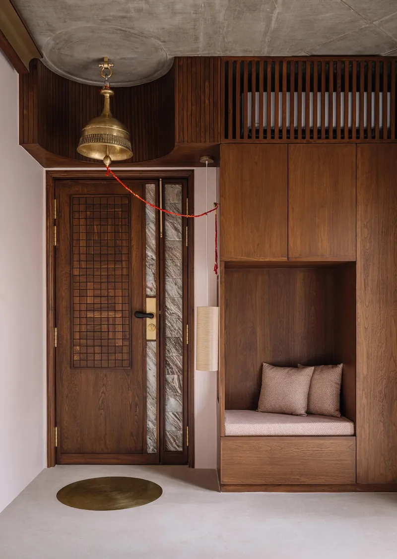 Entryway with walnut cabinetry, built-in bench seating, brass pendant fixture and gridded door with sidelight