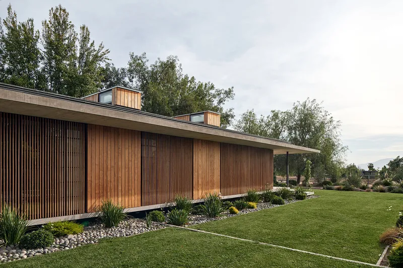 Long elevation showing alternating timber slat panels and concrete roof with timber clerestory monitors