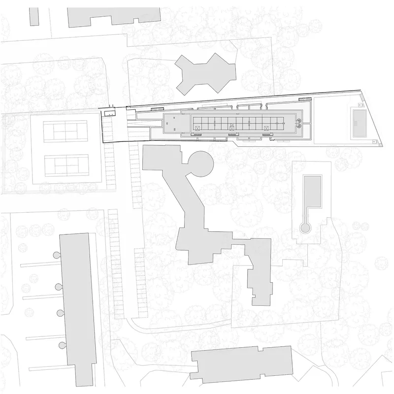 Site plan drawing showing the linear building footprint adjacent to parking areas and surrounding structures