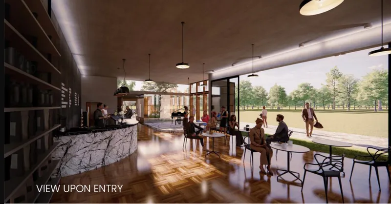 Entry view showing the open café interior, bar counter, seating area, and visual connection to the park.