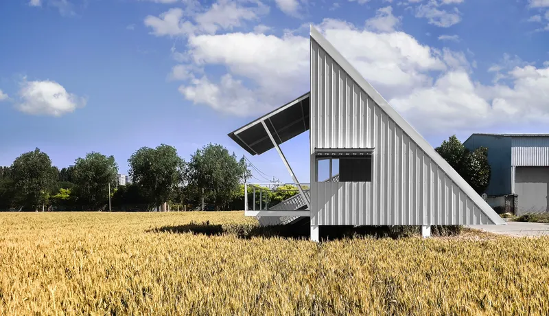 Side view of the cantilevered observation tower with open framework beneath partly cloudy skies