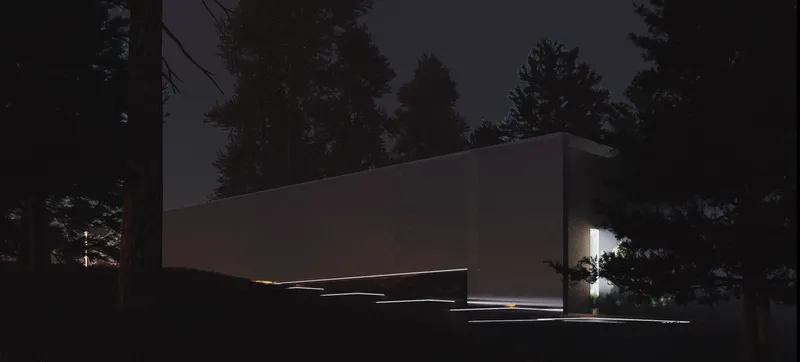 A monolithic cinema volume emerges quietly within the dark forest landscape, guided by subtle linear lighting.