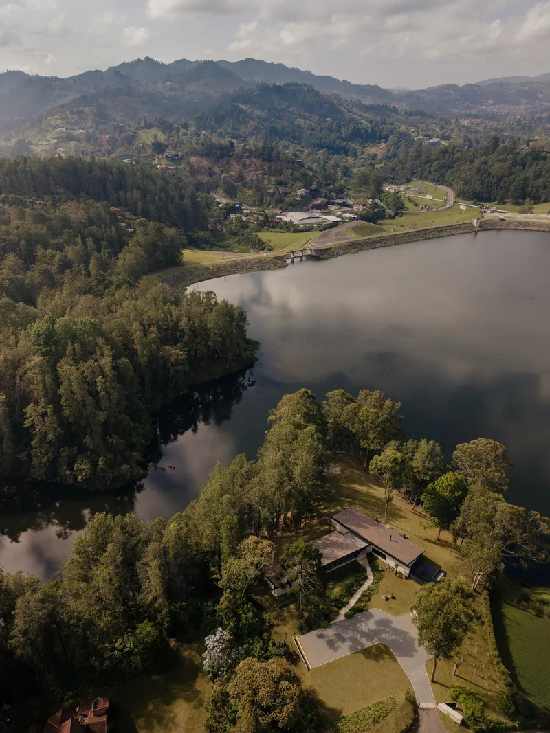 Aerial view of the low-slung residence on a tree-covered peninsula jutting into the reservoir