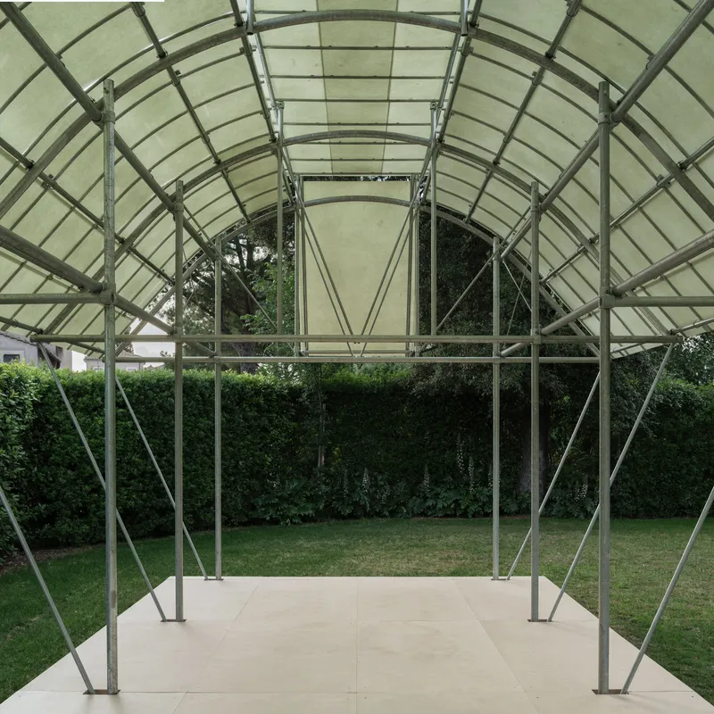 Interior view through the steel ribbed vault looking out to the garden and hedge beyond