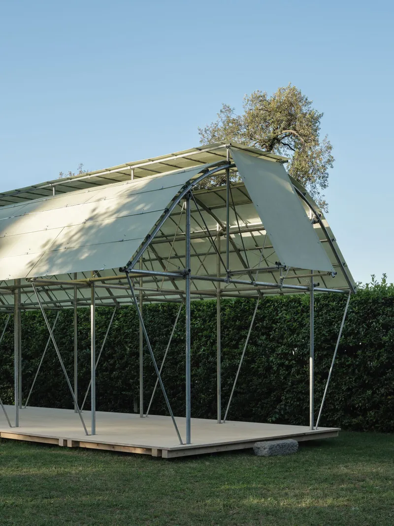 Angled view of the triangulated steel frame supporting the curved glass roof at one gable end