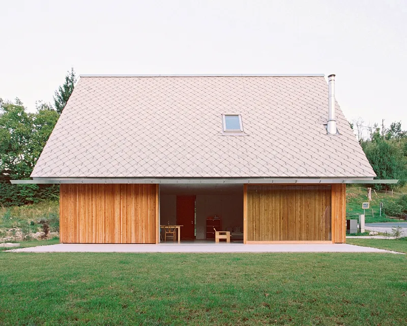 Facade view of the deeply recessed entrance loggia framed by timber shutters on both sides
