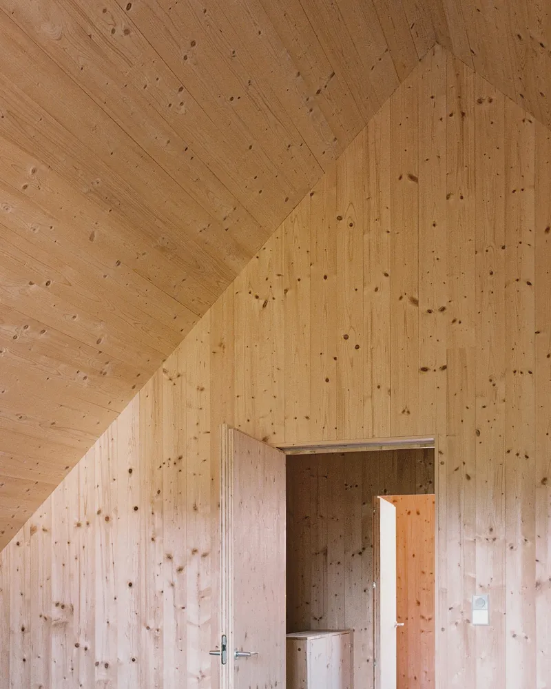 Vaulted plywood ceiling with vertical planking meeting at the ridge over a doorway