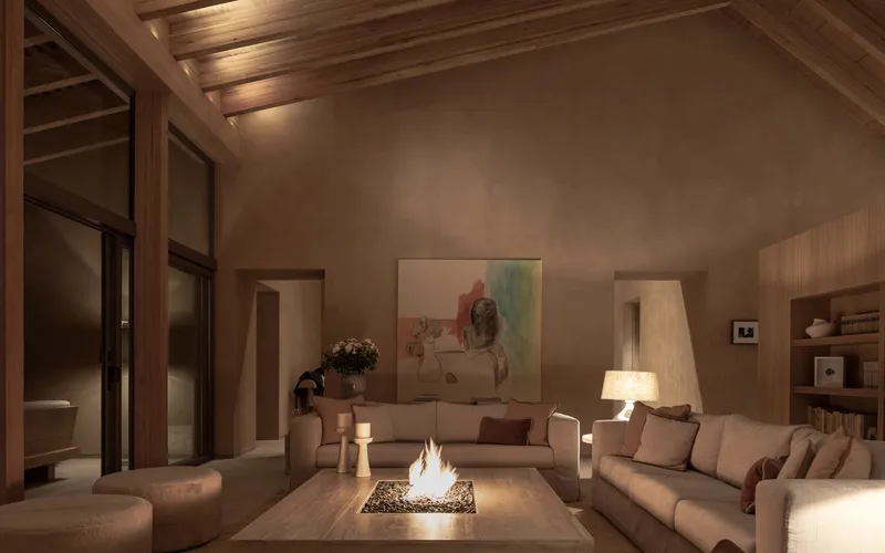 Living room with exposed timber ceiling and central fire table illuminated by evening lamplight