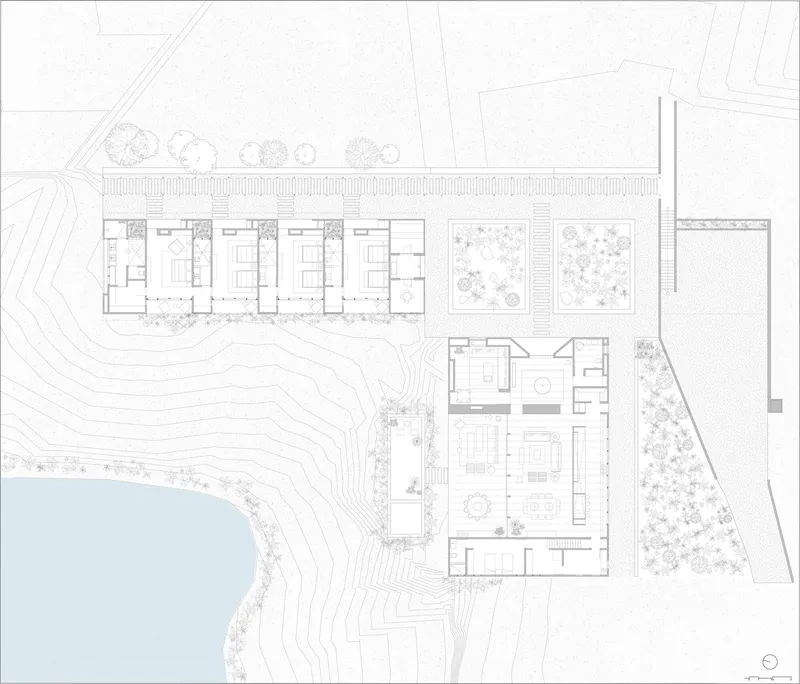 Site plan drawing showing multiple structures arranged along a waterfront with contour lines and planted areas