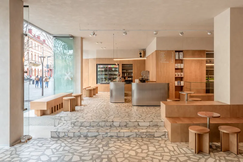 Ground floor retail space with terrazzo flooring and street-facing windows revealing pedestrians outside