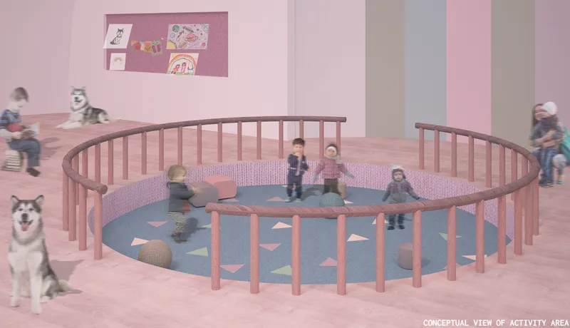 Circular play pit with timber railing and children on blue cushioned floor in pink interior